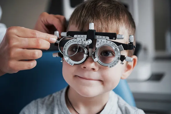 An ophthalmologist places adjustable optic lens frames on a 