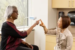 Dr. Kwon testing the motor skills of a patient by touching i