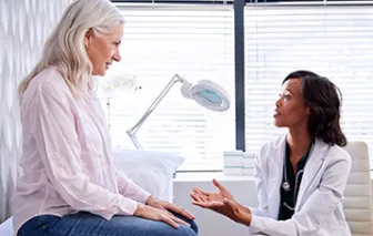 Older patient talking to a doctor in her office
