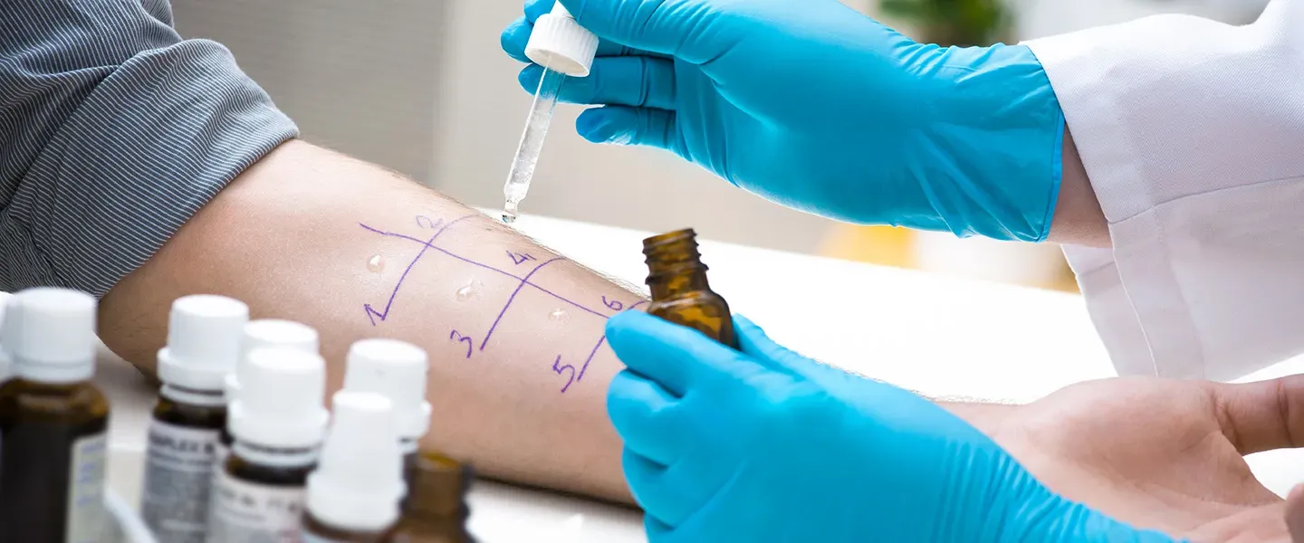 Close up of a doctor wearing blue gloves administering drops