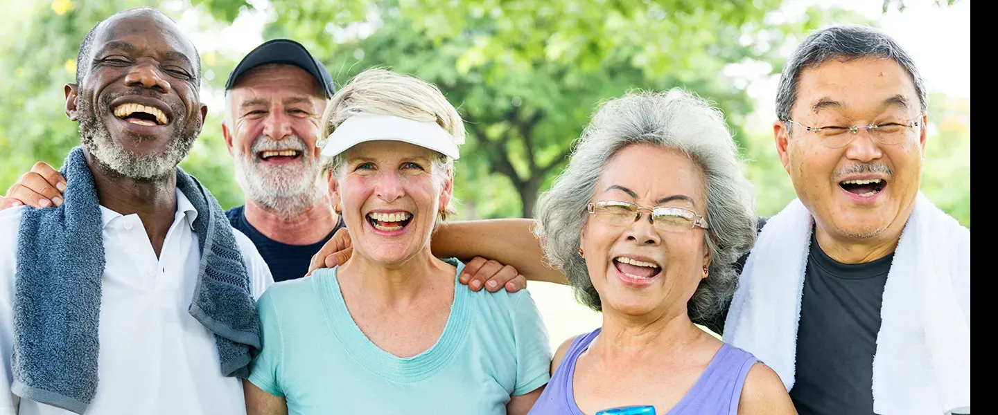 Five older adults of diverse ethnicity smile at the camera. 