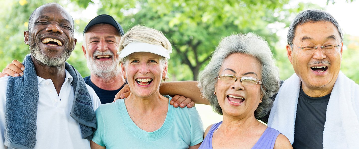 A diverse group of older adults smile at the camera after exercising.