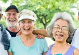 Five older adults of diverse ethnicity smile at the camera. 