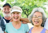 A diverse group of older adults smile at the camera after exercising.