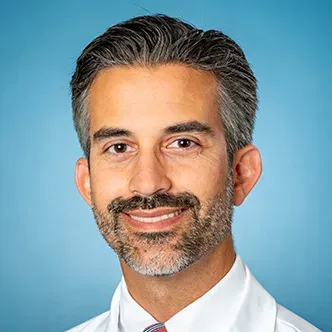 Dr. Volsky has short salt and pepper hair with a beard and m