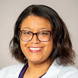 Amber Copeland has wavy dark brown hair, is wearing glasses 