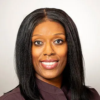 Kimberly Gray has long dark hair, is wearing a burgundy medi