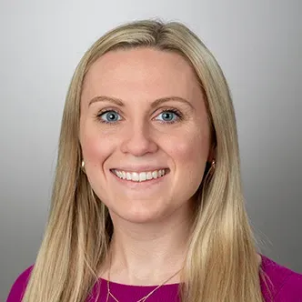 Sara Jorgensen has long blonde hair, is wearing a magenta to