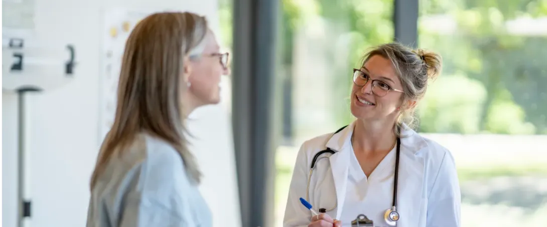 Female doctor taking notes smiling at a patient