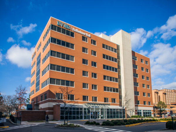 Hofheimer Hall is a medical office building with 6 floors. The bricks are reddish-orange and there is a bright blue sky with a few clouds.